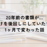 テーブルの上に、書類やプリント、封筒、クリアファイルなどが何層にも重なって積み上げられている様子。家庭で後回しになりがちな書類整理をイメージした写真。